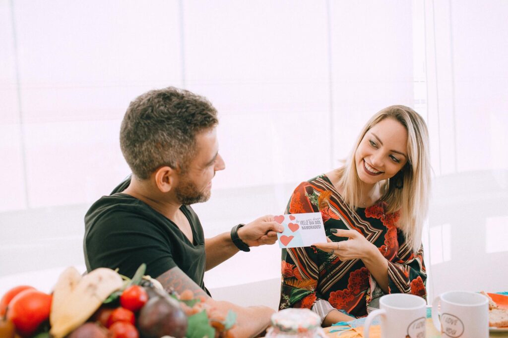 a man giving a greeting card to a woman